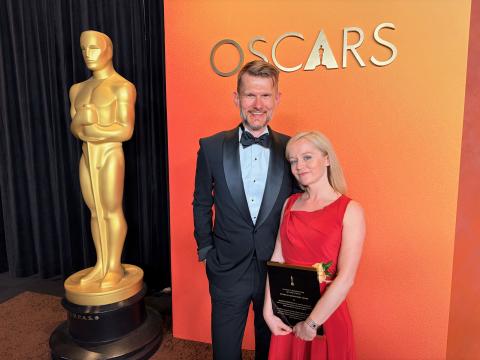 picture of Andrea Weidlich holding the award, there's also a man in the picture